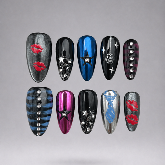 Ten coffin-shaped press-on nails arranged in two rows of five on a light gray gradient background. The nails feature various designs including red lipstick marks, silver stars, blue and pink stripes patterns , and metallic silver rhinestones.